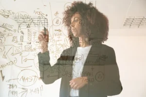 Focused young businesswomen writing virtual board concentrated young african american female manager holding marker making noted chart strategy business management concept