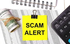 Desktop there are reports notepads calculator cash yellow sticker with text scam alert business concept